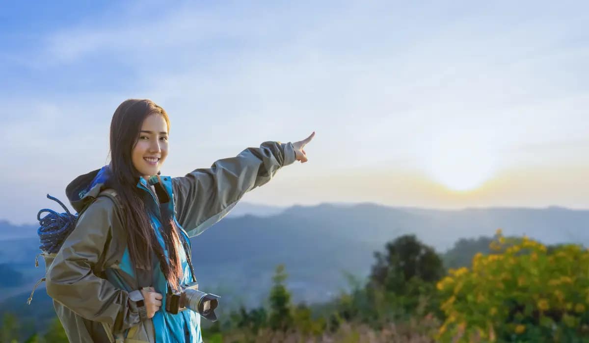 Young travel influencer taking photos at a scenic mountain viewpoint – how to become a travel influencer and explore the world