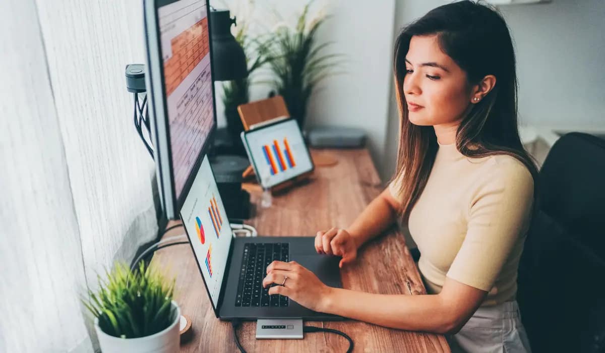 Independent virtual assistant working remotely on a laptop for foreign clients, managing online tasks from home office.”